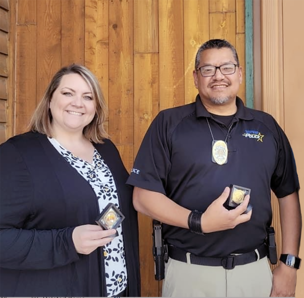 Photo of two people holding AMBER Alert challenge coins from the California Highway Patrol.