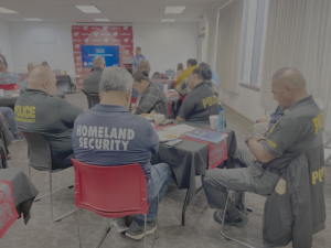 Participants shown at tables, with their heads bowed in prayer, during the AATTAP visit
