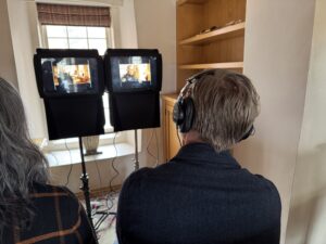 Film crew looking at monitor of video work while checking sound