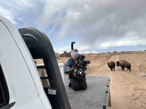 Photographer getting shots of bison and terrain for video setting