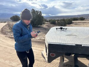 Photographer operating a drone for aerial views of setting