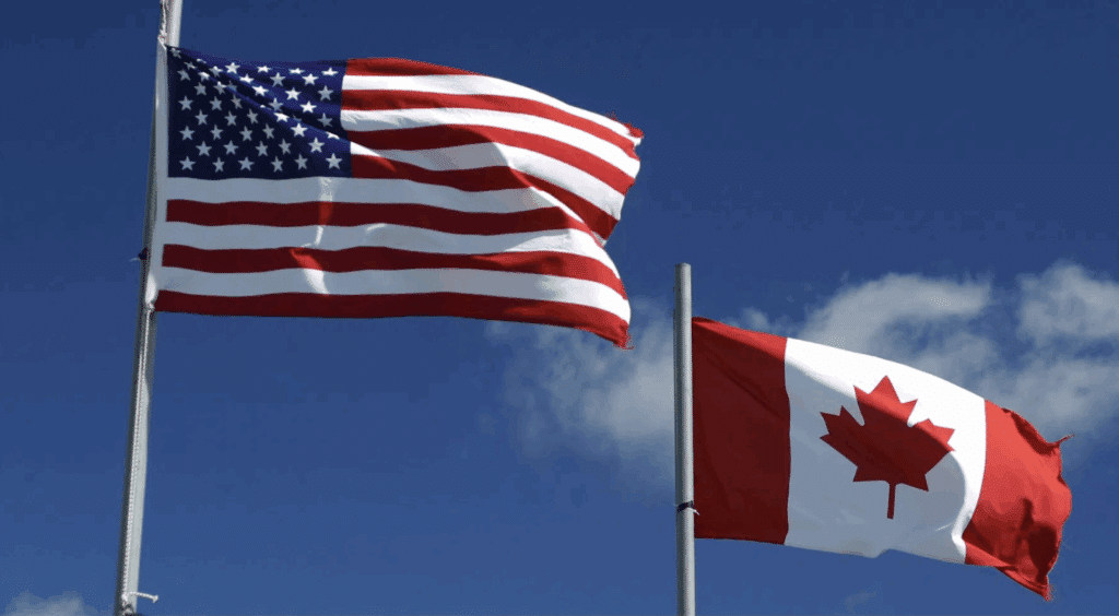 Photo of two flags, one U.S. and the other Canadian