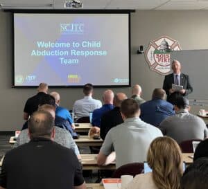 Man speaking to group of seated men and women