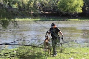Woman with search dog at river's edge
