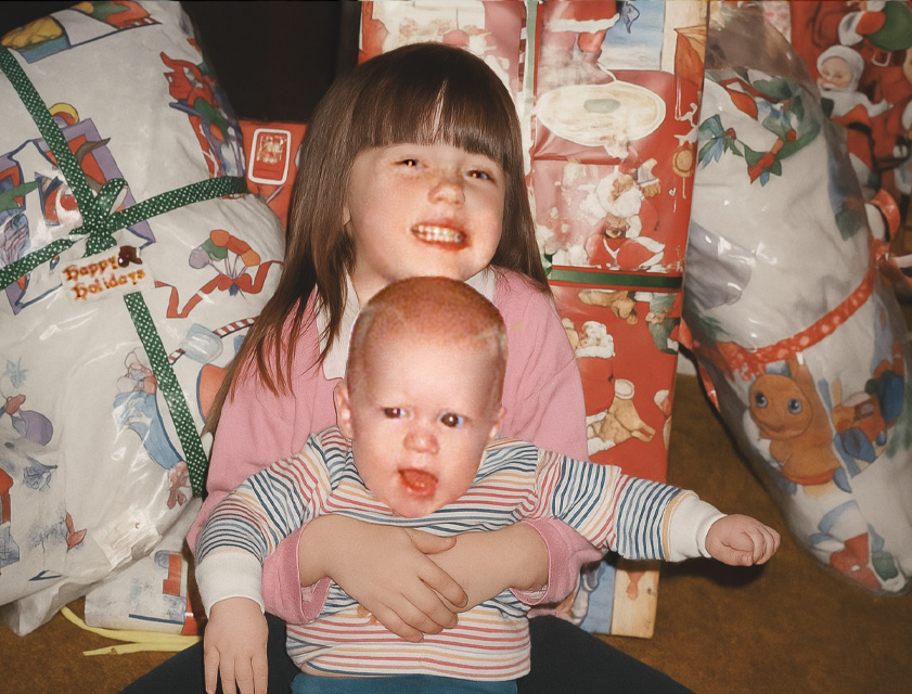 Amber Hagerman holding her baby brother, Ricky, in front of wrapped Christmas packages
