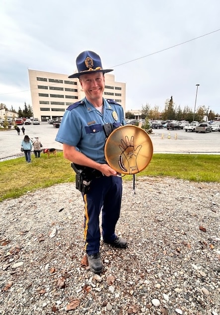 Alaska State Trooper holding commemorative object
