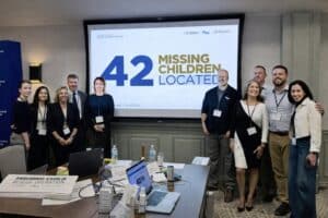 Equipo de la Operación de Rescate de Menores Desaparecidos de Westchester posando frente a una pantalla con el texto “42 menores desaparecidos localizados”
