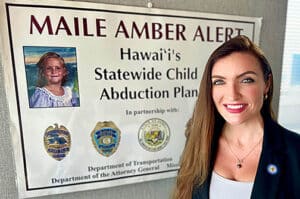 Hawaii’s AMBER Alert Coordinator Amanda Leonard standing in front of MAILE AMBER ALERT poster