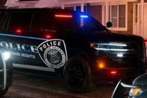 Madison Heights Police SUV at night with emergency lights on and parked in residential area.