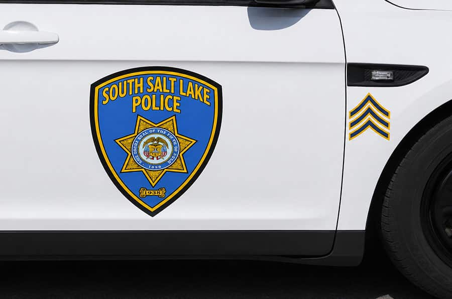 Cropped view of door of South Salt Lake Police cruiser with three stripes denoting a rank of sergeant for the officer assigned to the cruiser.