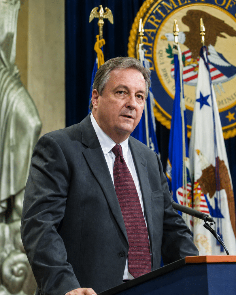 Man (Mark Simpson) standing at podium
