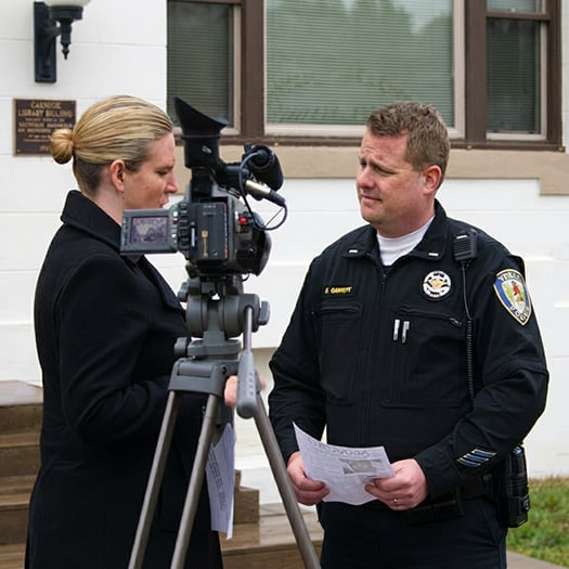 Photo of Dave Gamache talking with a journalist.