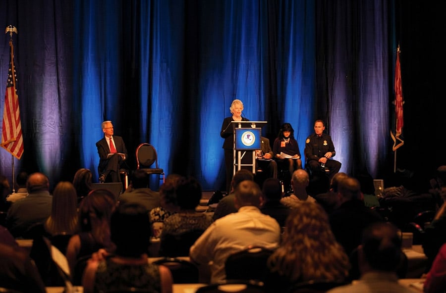 People on stage talking to a crowd of attendees