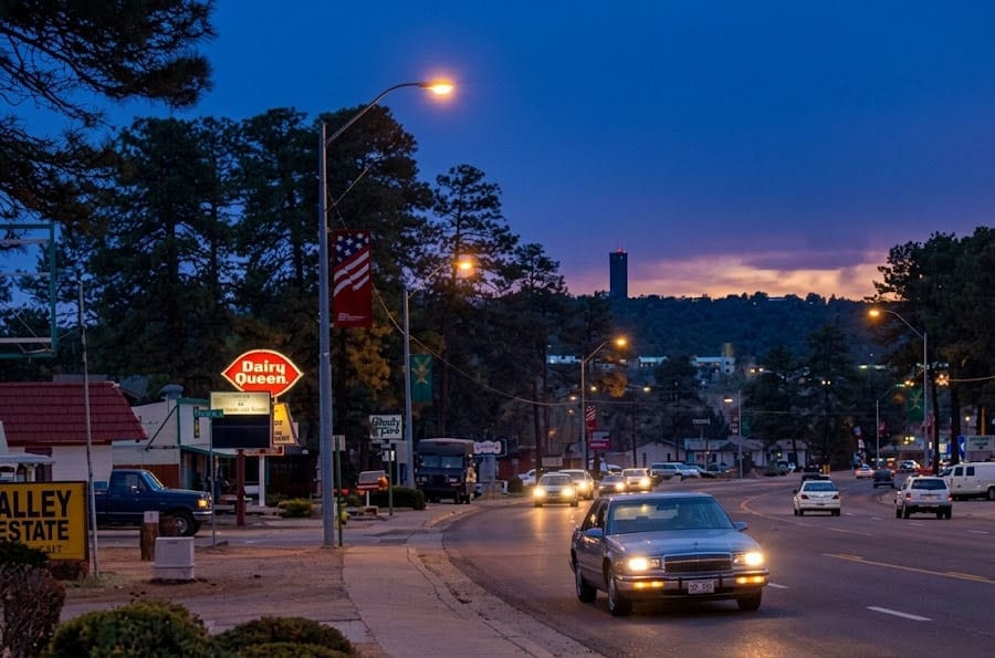Downtown Payson, Arizona, at night with a Dairy Queen, and cars driving on the road.