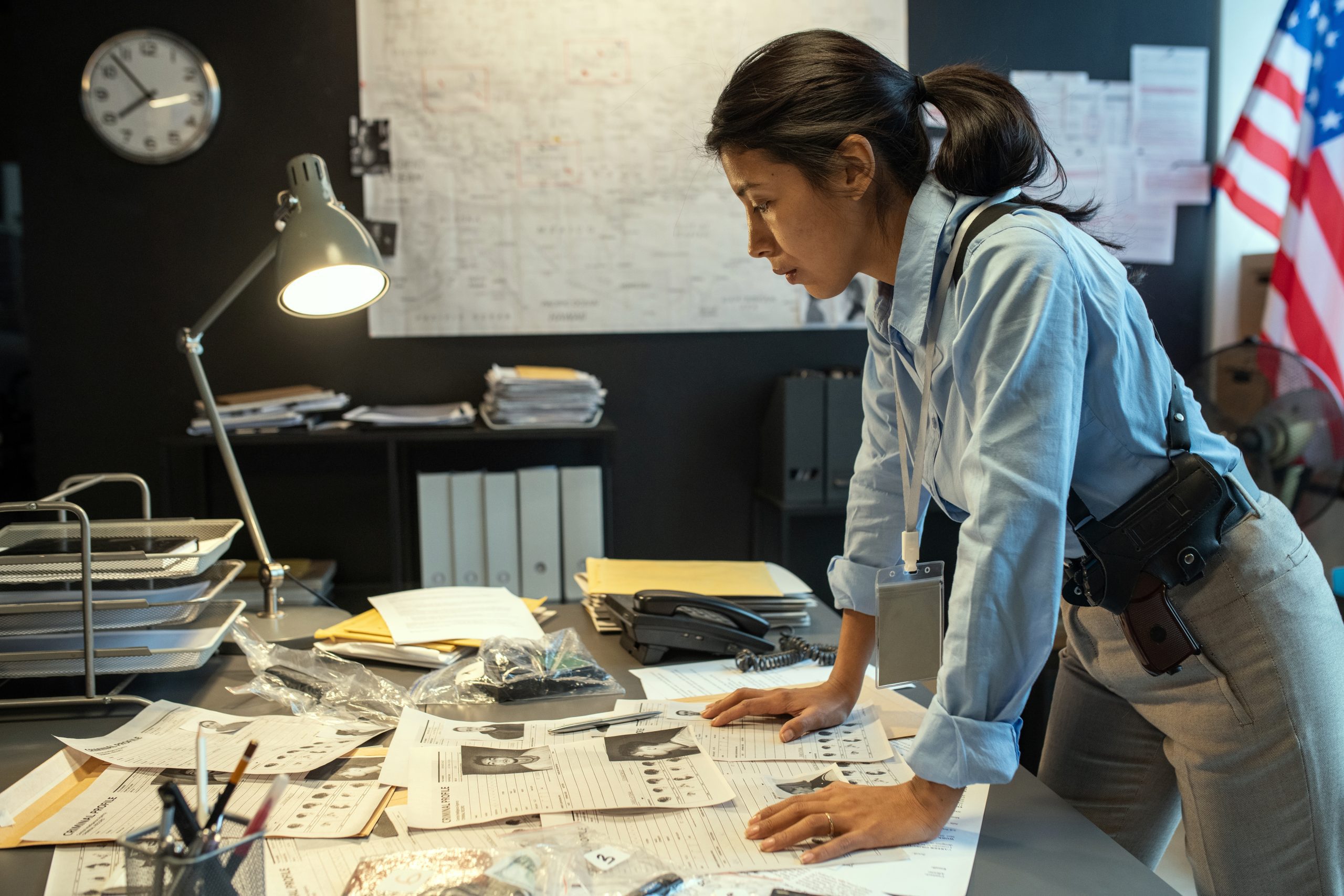 Female law enforcement investigator reviewing leads on a table